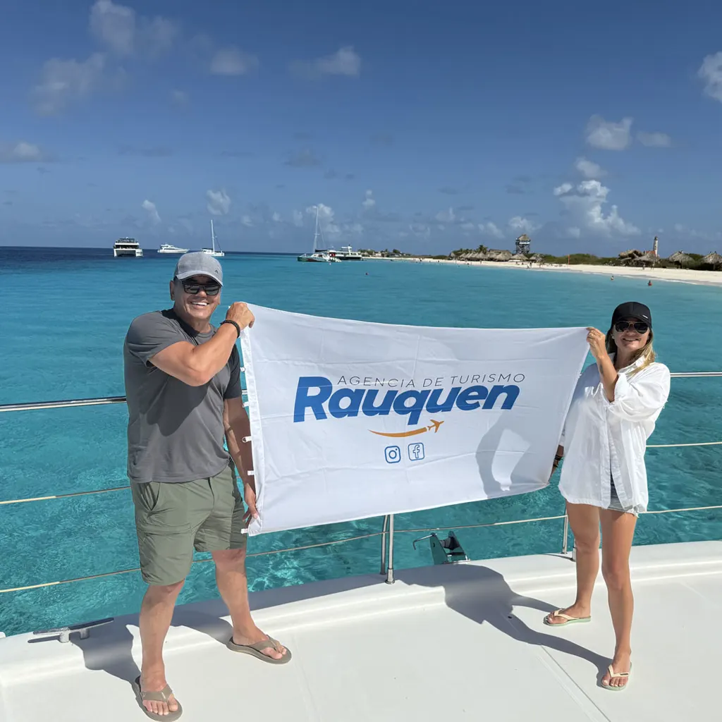 Pasajeros de Rauquén con la bandera de la agencia en un paseo por el mar Caribe